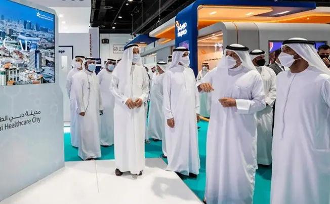 Delegation in traditional Emirati dress touring the Dubai Healthcare City stand at Duphat 2021