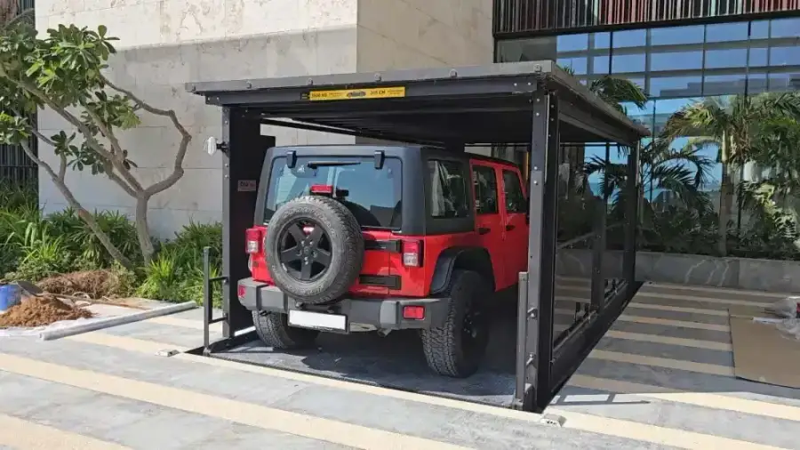 Red off-road SUV on a steel-framed car lift platform set into the paving at Jumeirah Bay Islands, Dubai